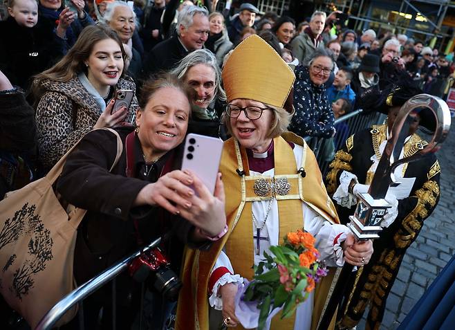 영국 성공회의 수장인 캔터베리 대주교로 취임한 세라 멀랠리(64) 대주교가 신자들과 사진을 찍고 있다. 세라 멀랠리는 성공회 역사상 첫 여성 대주교다. EPA 연합뉴스