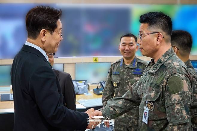 이재명 대통령이 어제(27일) 서울 용산 국방부 지휘통제실을 찾아 조성현 대령을 격려하며 악수하고 있는 모습. (청와대 제공)