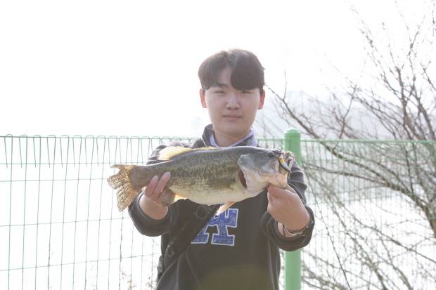 이번 대회 참가자가 잡은 물고기를 손에 들고 포즈를 취하고 있다.