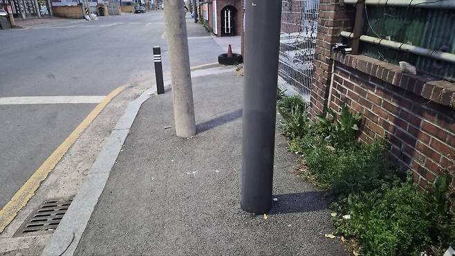 29일 광주 서구 유덕동의 한 보행로에 지장물 두 대가 잇따라 서 있어 시민의 통행을 방해하고 있다. 김현수 기자