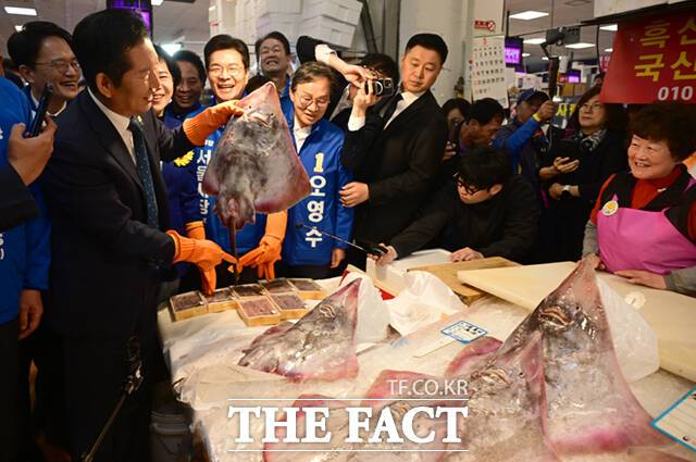 정청래 더불어민주당 대표(왼쪽 두 번째)와 박주민·전현희·정원오 (왼쪽부터) 서울시장 예비후보가 30일 서울 동작구 노량진수산물도매시장을 찾아 상인들과 인사하며 홍어를 들어보이고 있다. /이새롬 기자