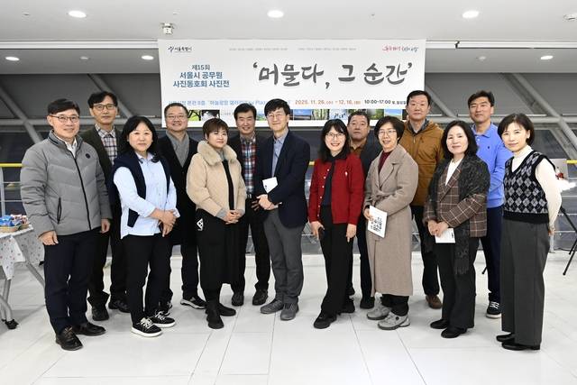 서울특별시 공무원 사진동호회 회원들이 지난해 11월 열린 제15회 전시 ‘머물다, 그 순간’에서 기념사진을 촬영하고 있다. 서울시청 제공