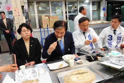조국혁신당 조국 당대표가 29일 영월 서부시장에서 신장식 국회의원 등과 함께 영월의 대표 먹거리인 전병을 시식하고 있다.