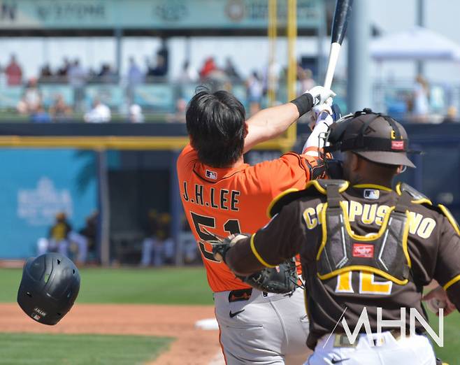 (이정후가 샌디에이고를 상대로 스프링캠프 경기에서 헬멧이 벗겨질 정도의 큰 헛스윙을 하고 있다)