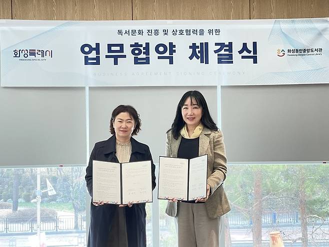 화성동탄중앙도서관에서 허윤행 동탄청소년문화의집 관장(오른쪽)과 윤미영 화성특례시 도서관정책과장(왼쪽)이 업무협약식을 마친 후 기념 촬영을 하고 있다. 사진제공 화성시