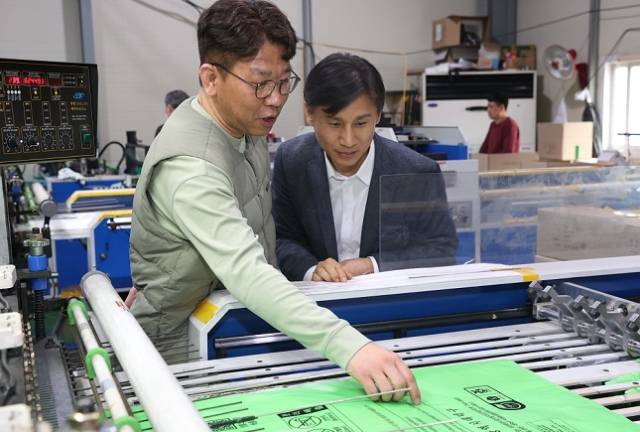 백호성 조달청 구매사업국장(오른쪽)이 충남 금산군 소재 종량제봉투 생산기업인 경승산업을 방문해 생산시설을 둘러보고 있다. 조달청 제공