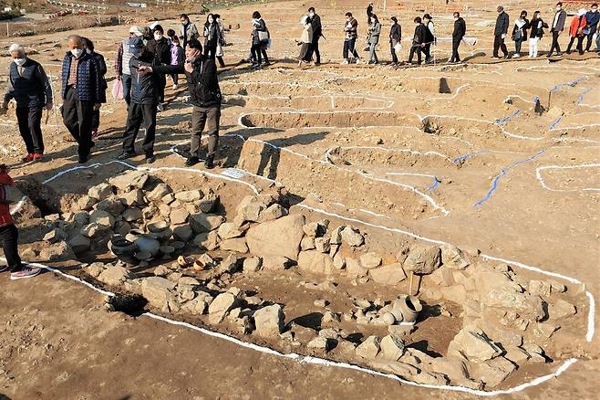 2020년 11월11일 석동 가야 유적지 현장공개설명회에 참석한 수백명의 사람들이 아세아문화재연구원 관계자 안내에 따라 현장을 둘러보고 있다. 흰 선으로 표시된 모든 구멍이 발굴된 무덤이다. 최상원 기자