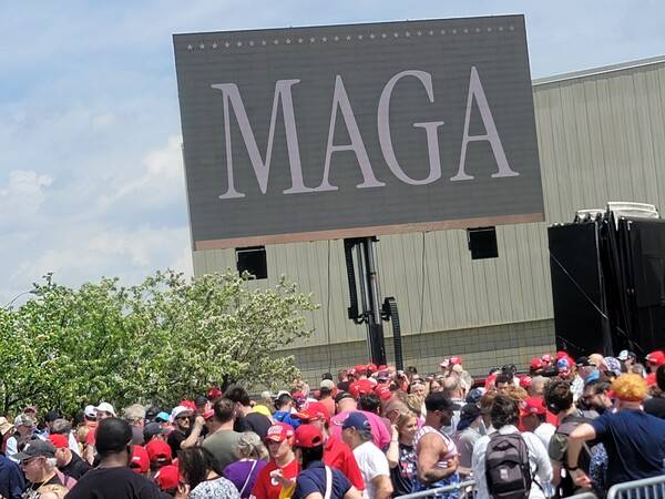 도널드 트럼프 미국 대통령의 취임 100일 연설을 듣기 위해 미국 미시간주 머콤 카운티 현장을 찾은 지지자들이 '마가'(MAGA·Make America Great Again·미국을 다시 위대하게·트럼프의 선거 구호)라는 문구가 새겨진 전광판 아래서 입장을 기다리고 있다. 2025.4.30 연합뉴스
