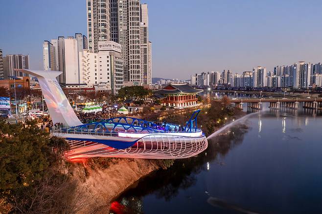 지난해 12월 울산시가 73억여원을 들여 고래를 본떠 지은 태화루 스카이워크. 뒤편 기와 지붕 구조물이 506억원을 들여 복원한 태화루다. 일부 관람객들은 조망도 별로 차이가 나지 않고 태화루와 조화를 이루지도 않는 스카이워크를 설치한 이유를 모르겠다는 반응을 보이고 있다. 울산시 제공