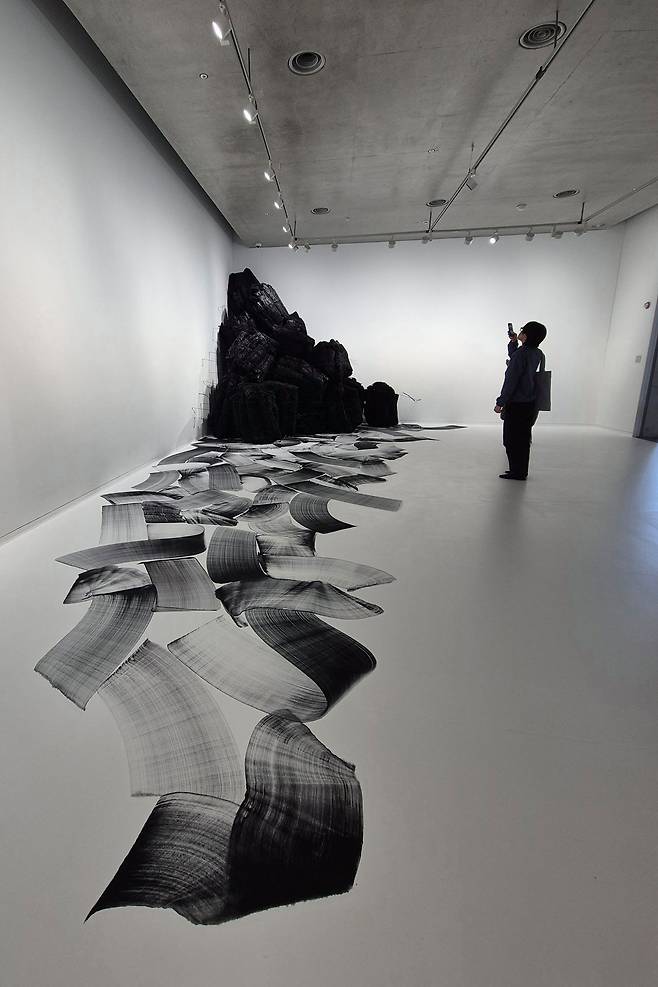 숯 조각과 숯으로 그린 바닥 그림이 산에서 물이 흐르듯 이어진다. 권근영 기자