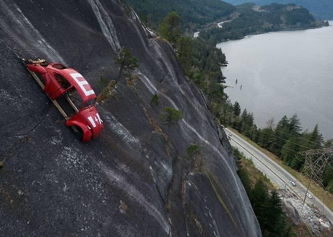 6일(현지시간) 캐나다 브리티시컬럼비아(BC)주 스쿼미시의 씨투스카이 고속도로 위 절벽에 속이 비어 있는 폴크스바겐 비틀이 매달려 있다. AP뉴시스