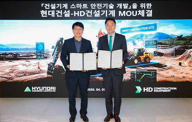 7일 서울 종로구 계동 현대건설 본사에서 열린 업무협약식에서 김제영 현대건설 안전수행지원실장(왼쪽)과 최태근 HD건설기계 글로벌 통합 영업본부장이 기념촬영을 하고 있다. 현대건설 제공