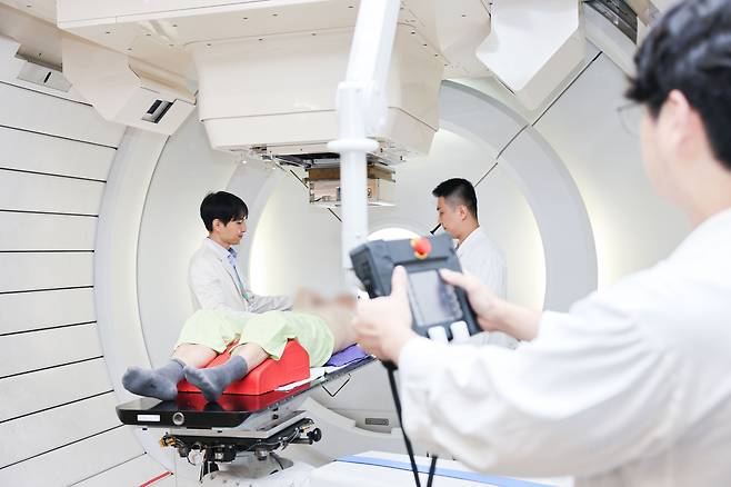 유정일 삼성서울병원 방사선종양학과 교수(왼쪽)가 간암 환자를 대상을 양성자 치료에 앞서 설명하고 있다.<삼성서울병원 제공>