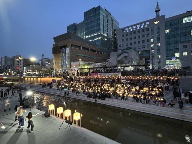 야간 조명이 켜진 성북천 수변활력거점에서 시 민들이 여유롭게 공연과 휴식을 즐기고 있다. 성북구청 제공