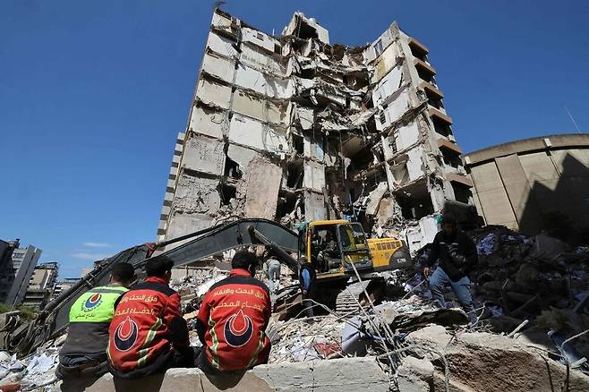 이스라엘의 무차별 공습 이튿날인 9일 레바논 수도 베이루트의 폐허가 된 건물 앞에서 구조대의 중장비가 잔해를 치우고 있다. AFP 연합뉴스