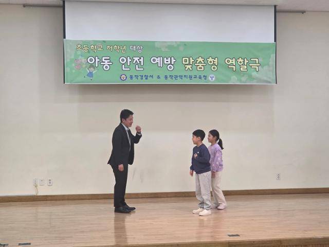 남병진(왼쪽) 한국일보 기자가 7일 서울 동작구 영화초등학교에서 진행된 '체험형 아동 안전 역할극'에 직접 참여해 유괴범 역할을 맡고 있다. 동작경찰서 제공