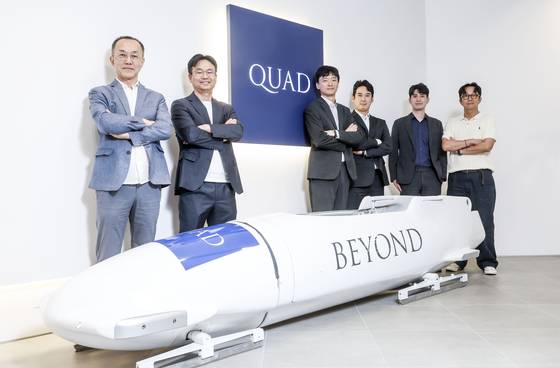 황호성 쿼드자산운용 사장(왼쪽 첫번째), 한상균 운용부문 대표(왼쪽 두번째)를 비롯한 임직원들이 서울 여의도의 사무실 입구에 전시된 봅슬레이와 함께 포즈를 취했다. 4명이 힘을 합쳐야 하는 봅슬레이처럼, 숫자 4를 뜻하는 '쿼드(Quad)' 사람들은 투자도 함께 끌고 미는 것이라고 믿는다. 김성룡 기자