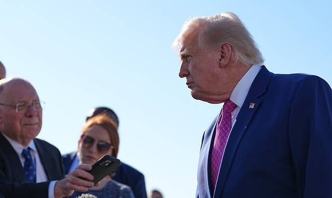 도널드 트럼프 미국 대통령이 10일(현지시간) 메릴랜드주 앤드루스 합동기지에서 버지니아주 샬러츠빌로 향하기 위해 에어포스원에 탑승하기 전 취재진의 질문에 답하고 있다. AP 연합뉴스