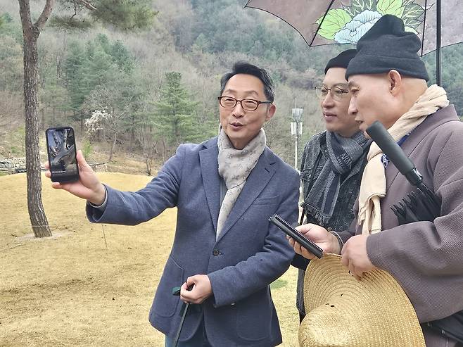 이석구(맨왼쪽부터) FAMS 2026 조직위원장, 한영용 앰버서더, 홍산 스님이 금선사 사찰에 관련한 스토리를 앱을 통해 공유하면서 사찰에 관해 대화꽃을 피우고 있다.