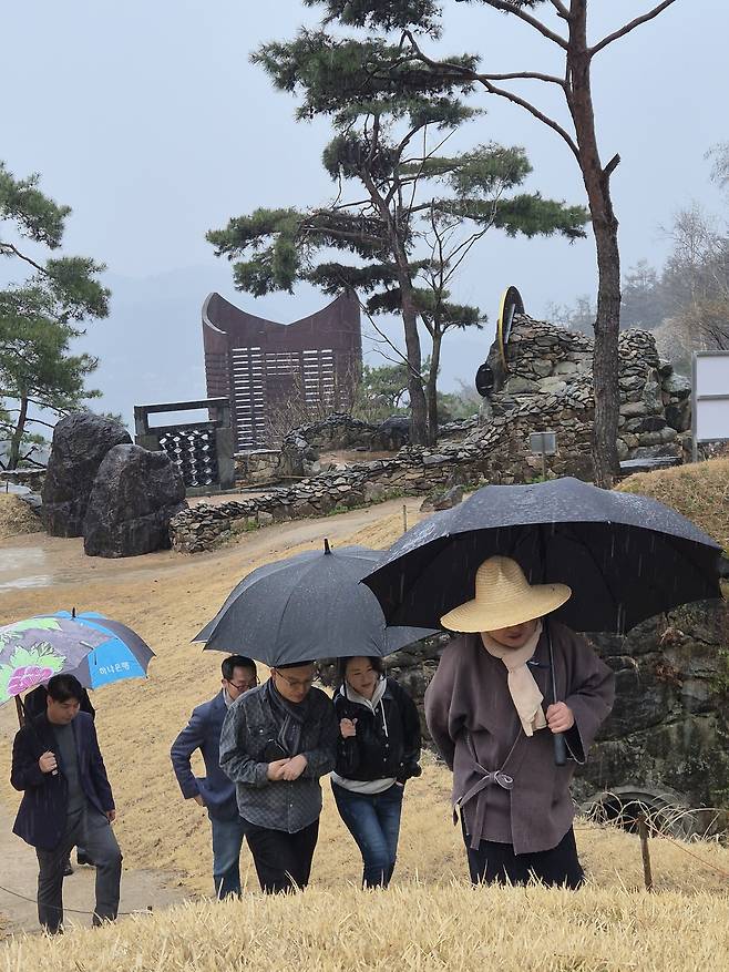 금선사를 방문한 FAMS 2026 운영진이 홍산(맨오른쪽) 스님의 안내를 받으며 사찰 본 건물로 향하고 있다.