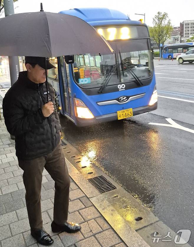 오세훈 서울시장이 순천향대병원 정류장에서 우산을 쓰고 472번 버스를 기다리고 있다.
