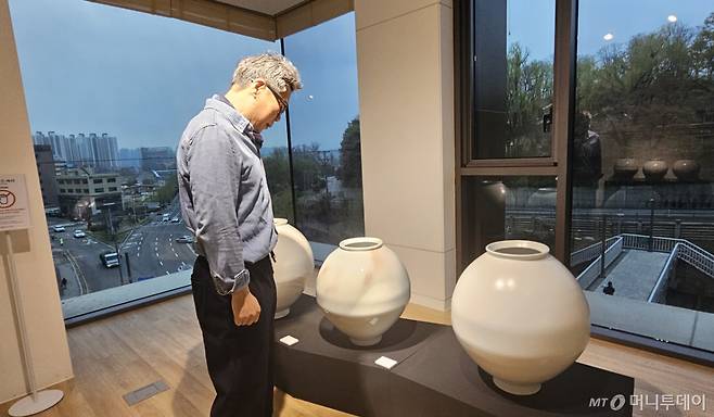 10일 모다갤러리에서 열린 '나를 담은 자리' 전시에서 이규 작가가 자신의 작품을 내려다보고 있는 모습. / 사진 = 오진영 기자