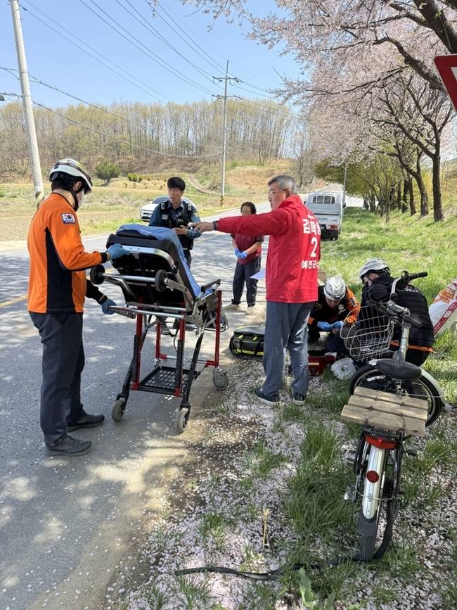 ▲ 13일 오전 12시 유천면 도로에서 자전거를 타고 이동하던 70대 남성이 중심을 잃고 쓰러지자 현장을 지나던 김 예비후보가 이를 목격하고 차량에서 내려 긴급 조치 후 119 이송 과정을 지켜보고 있는 장면. 이상만기자