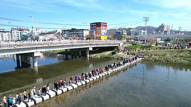 ▲ 제32회 의성군민건강걷기대회가 열린 12일 의성군 구봉공원 일원에서 참가자들이 남대천 징검다리를 따라 줄지어 이동하고 있다. 의성군 제공