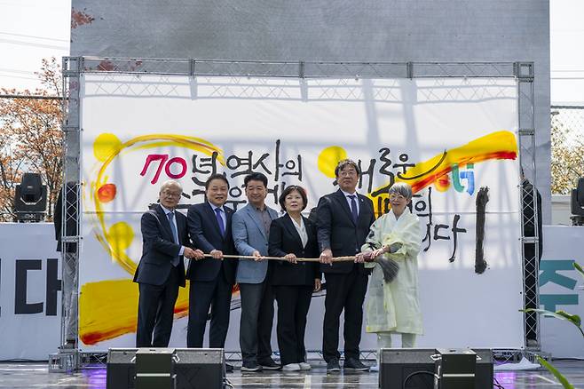 ▲ 경북보건대학교 개교 70주년 기념식에 참석한 내빈들이 캘리그라퍼 마야 손명주 작가가 '기억과 공감'을 주제로 한 70주년 기념 퍼포먼스 후 기념촬영을 하고 있다.(왼쪽부터 한일교육재단 이신호 이사장, 송설단교육재단 김상근 이사장, 김천시의회 나영민 의장, 김천시장 권한대행 조현애 부시장, 경북보건대학교 이은직 총장, 캘리그라퍼 마야 손명주 작가)