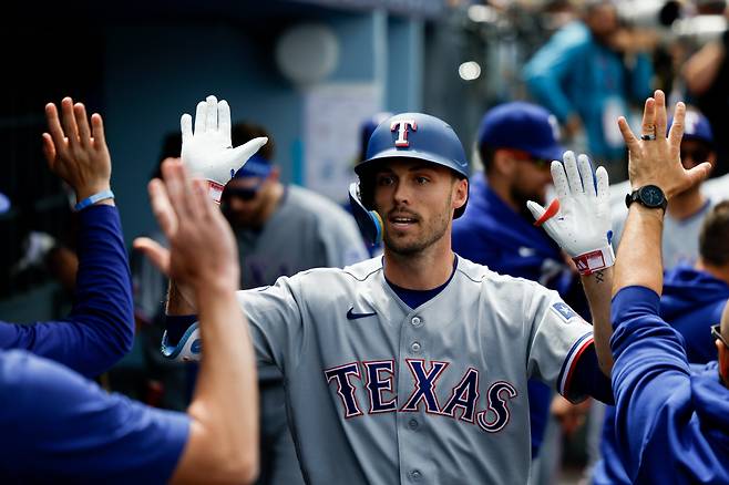 텍사스 레인저스 에반 카터가 3회초 사사키 로키로부터 솔로홈런을 빼앗고 들어와 동료들과 하이파이브를 하고 있다. AP연합뉴스