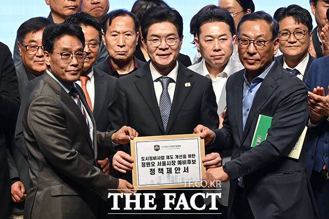 정한호 서울도시정비조합협회 이사장(왼쪽)이 정원오 서울시장 후보에게 '도시정비사업 제도 개선을 위한 정책제안서'를 전달하는 모습.