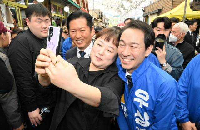 ▲ 정청래 더불어민주당 당대표와 우상호 도지사 예비후보가 12일 오후 ‘국민 곁으로! 현장속으로’ 강원 민생현장 방문의 일환으로 춘천 풍물시장을 찾아 시민들과 사진을 찍고 있다. 김정호 기자