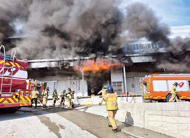 소방관들이 이날 검은 연기가 치솟는 화재 현장에서 진화와 수색 작업을 진행하는 모습. 연합뉴스