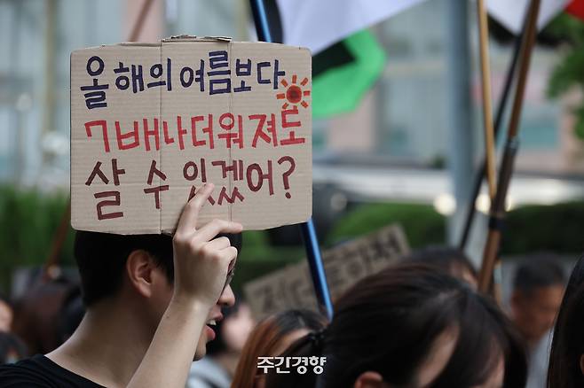 지난해 9월 27일 서울 종로구 광화문 일대에서 기후정의행진 참가자가 더워지는 여름에 대한 대책을 촉구하는 손팻말을 들고 행진하고 있다. 한수빈 기자