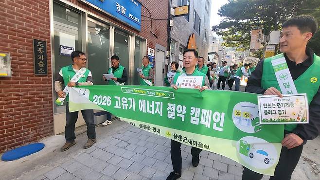 이정호 울릉군 새마을회장(앞줄 가운데)과 회원들이 지난 13일 울릉읍 일원에서 열린 전국 동시 에너지 절약 캠페인에 참여해, 생활 속 실천 수칙이 담긴 피켓과 현수막을 들고 홍보 활동을 펼치고 있다. /울릉군 새마을회 제공