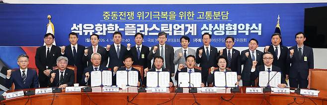 더불어민주당 을지로위원회 주최로 14일 국회에서 열린 중동전쟁 위기극복을 위한 고통분담, 석유화학-플라스틱업계 상생 협약식에서 참석자들이 협약서에 서명한 뒤 기념 촬영을 하고 있다. 연합뉴스