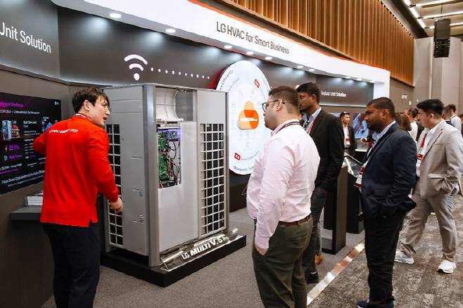 LG전자 직원이 고효율 인버터 컴프레서가 적용된 LG전자의 멀티 V 5 프로(MULTI V 5 Pro)와 데이터 기반 통합 제어 솔루션 '비컨(BECON)'을 소개하고 있다.(사진=LG전자)