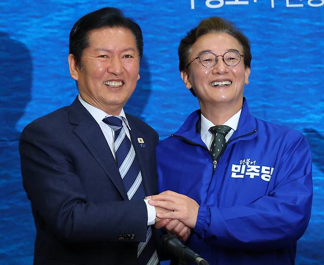 더불어민주당 전재수(오른쪽) 부산시장 후보가 지난 15일 부산 동구 부산항국제컨벤션센터에서 정청래 대표가 준 파란색 점퍼를 입고 함께 기념 사진을 찍고 있다. /연합뉴스