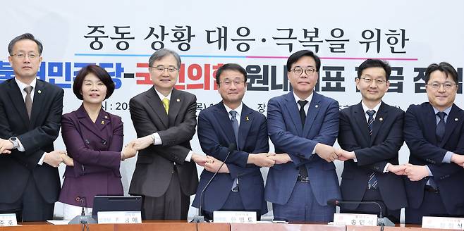 16일 국회에서 열린 중동 상황 대응·극복을 위한 더불어민주당-국민의힘 원내대표 긴급 점검 회의에서 기념 촬영을 위해 손을 맞잡고 있다. 왼쪽부터 이형일 재정경제부 1차관, 한정애 더불어민주당 정책위의장, 조현 외교부 장관, 한 원내대표, 송 원내대표, 윤창렬 국무조정실장./뉴스1