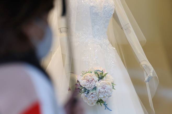 한 웨딩드레스 판매점 앞을 시민들이 지나가고 있다. 기사와 관련 없음./연합뉴스