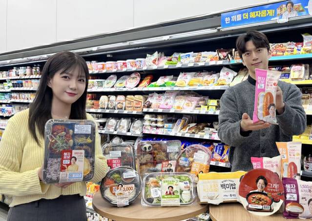 GS25에서 모델이 혜자로운 브랜드 상품 앞에서 포즈를 취하고 있다. (제공=GS리테일)