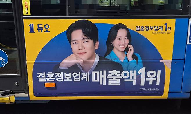 23일 정오 무렵 서울 중구 서울역버스환승센터를 지나는 A버스회사의 시내버스 차량에 결혼정보회사 ‘듀오’ 광고가 보인다. 김동환 기자