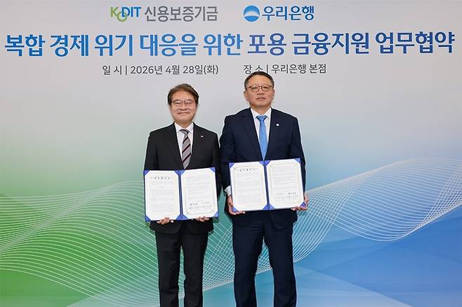 지난 28일 강승준 신용보증기금 이사장(사진 왼쪽)이 우리은행 본점에서 열린 '복합 경제 위기 대응을 위한 포용 금융지원 업무협약식'에서 정진완 우리은행장과 기념사진을 찍고 있다. ⓒ신용보증기금 제공