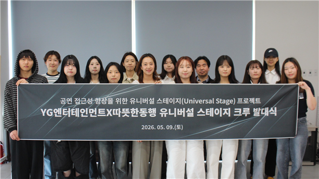 사진=따뜻한동행과 YG엔터테인먼트가 진행한 ‘유니버설 스테이지 크루’ 발대식에서 참여자들이 현수막을 들고 기념촬영을 하고 있다.