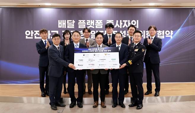 김영훈 고용노동부 장관이 15일 오전 서울지방고용노동청에서 열린 배달 플랫폼 종사자의 안전하고 건강한 일터 조성을 위한 협약식에서 서명 보드를 들고 참석자들과 기념 촬영을 하고 있다.(사진=고용노동부 제공)