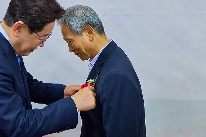 이재명 대통령이 15일 경북 안동의 한 식당에서 이 대통령 모교에서 담임을 맡았던 은사 박병기 선생님과 오찬을 하며 카네이션을 달아주고 있다. 사진 청와대