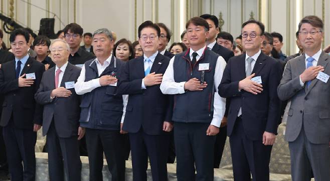 이재명 대통령이 지난 5월1일 청와대 영빈관에서 열린 노동절 기념식에서 양대 노총 위원장을 비롯한 참석자들과 국민의례를 하고 있다. 청와대가 노동절 기념식을 개최한 것은 사상 처음이며, 양대 노총이 노동절 행사를 함께하는 것도 이번이 처음이다.(사진 = 연합뉴스)