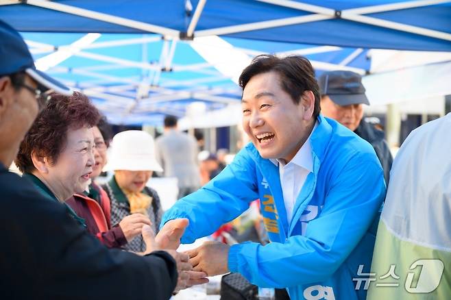 김관영 전북지사 후보(무소속)가 환한 얼굴로 시민들과 손을 잡고 있다.(김관영 후보 캠프 제공. 재판매 및 DB금지)/뉴스1