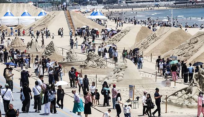 '2026 해운대 모래축제'가 한창인 지난 17일 부산 해운대구 해운대수욕장을 찾은 시민과 관광객이 다양한 모래작품을 구경하고 있다. 모래작품 전시는 축제가 끝난 뒤에도 내달 14일까지 이어진다. 송봉근 객원기자
