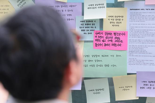 강남역 살인사건 10주기인 17일 서울 강남구 강남역 10번 출구에서 한 시민이 추모 포스트잇을 바라보고 있다. 정효진 기자